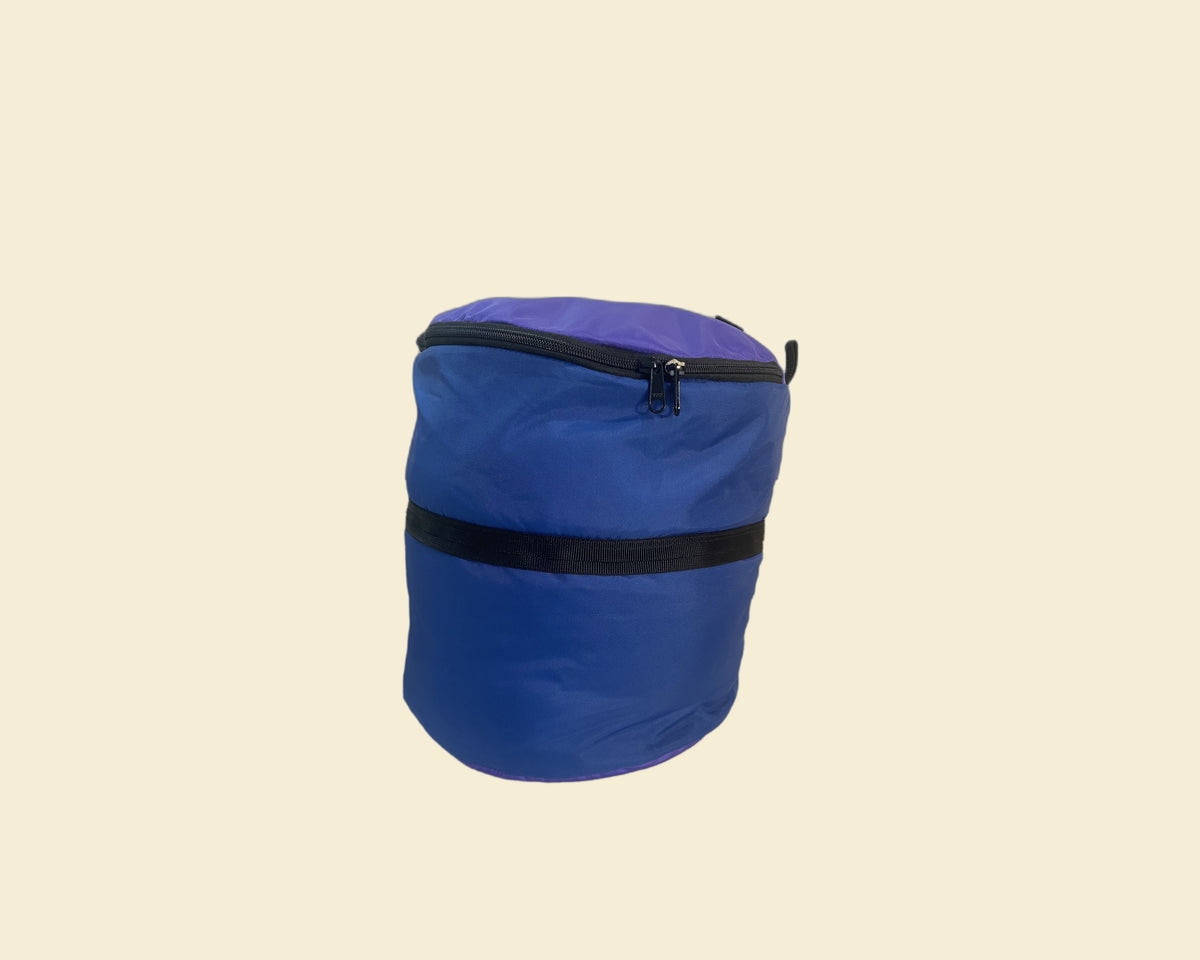 A blue cylindrical soft bag or pouch with a purple top panel, black zipper, and a black horizontal strap detail, shown on a plain white background.