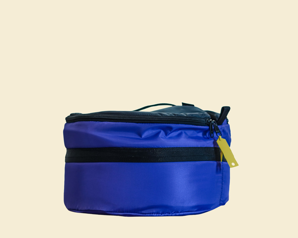 Ruby Moons packing round in blue with a blank yellow name tag attached, shown on a light beige background